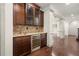 Finished basement with a wet bar including a wine fridge and tile backsplash at 4015 Roberts Crest Ln, Suwanee, GA 30024