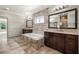 Elegant bathroom featuring double vanities, soaking tub, and tile accent wall creating a spa-like retreat at 4015 Roberts Crest Ln, Suwanee, GA 30024