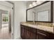 Modern bathroom with granite countertop, vanity and mirror, with tiled floor and a view to the exterior at 4015 Roberts Crest Ln, Suwanee, GA 30024