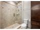 Bathroom showcases a tiled shower with glass door, toilet, and wood storage cabinet at 4015 Roberts Crest Ln, Suwanee, GA 30024