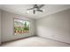Bright bedroom with plush carpeting, neutral walls, a ceiling fan, and a large window with backyard view at 4015 Roberts Crest Ln, Suwanee, GA 30024