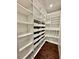 Spacious walk-in closet featuring custom white shelving, drawers, and wire baskets for optimal organization at 4015 Roberts Crest Ln, Suwanee, GA 30024
