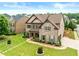 Charming two-story home showcasing a lush green lawn, stone walkway and professional landscaping at 4015 Roberts Crest Ln, Suwanee, GA 30024