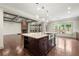Open kitchen with a large island, stainless steel appliances, and hardwood floors, flowing into a living area with fireplace at 4015 Roberts Crest Ln, Suwanee, GA 30024