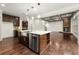 Spacious kitchen featuring a large island with a stainless steel sink, dark wood cabinets, and hardwood floors at 4015 Roberts Crest Ln, Suwanee, GA 30024
