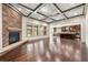 Bright living room featuring stone fireplace, coffered ceilings, hardwood floors and open kitchen access at 4015 Roberts Crest Ln, Suwanee, GA 30024