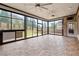 Well-lit sunroom featuring stone floors, ceiling fans, and large windows providing backyard views at 4015 Roberts Crest Ln, Suwanee, GA 30024