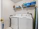 Functional laundry room equipped with washer, dryer, shelving for storage, and an ironing board at 4506 Westcliff Ne Trce, Roswell, GA 30075