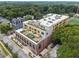 Aerial view of a modern apartment building with rooftop amenities and lush surrounding greenery at 112 Rogers Street Ne # 505, Atlanta, GA 30317