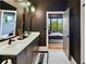 Modern bathroom featuring double vanity, white countertop, sleek black fixtures, and a glimpse into the bedroom at 112 Rogers Street Ne # 505, Atlanta, GA 30317