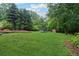 Expansive backyard with lush green grass and mature trees, great for outdoor activities at 251 Sabrina Ct, Woodstock, GA 30188