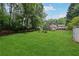 Lush green backyard with mature trees, storage shed, and trampoline at 251 Sabrina Ct, Woodstock, GA 30188