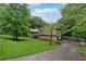 Landscaped home with stone accents and long driveway surrounded by mature trees at 251 Sabrina Ct, Woodstock, GA 30188