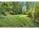Spacious backyard with healthy green grass surrounded by a lush forest at 400 Old Ivy Ne Rd, Atlanta, GA 30342