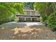 Exterior view of a house with a balcony and a three-car garage surrounded by green trees at 400 Old Ivy Ne Rd, Atlanta, GA 30342