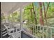 Covered porch with a gray floor and a white railing with a view of the wooded landscape at 400 Old Ivy Ne Rd, Atlanta, GA 30342