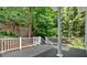 The porch has a wooded view, white railings, and a set of stairs leading to the backyard at 400 Old Ivy Ne Rd, Atlanta, GA 30342