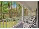 Long covered porch with a gray floor, white railings, and a view of the wooded landscape at 400 Old Ivy Ne Rd, Atlanta, GA 30342