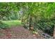 Backyard with a creek surrounded by lush, mature landscaping at 400 Old Ivy Ne Rd, Atlanta, GA 30342