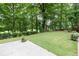 Serene backyard featuring a concrete patio, well-manicured lawn, and lush greenery for privacy at 5844 Brookstone Nw Walk, Acworth, GA 30101
