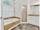 Bright bathroom with soaking tub, walk-in shower, white cabinets and stone countertops at 5844 Brookstone Nw Walk, Acworth, GA 30101