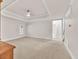 Well-lit carpeted bedroom with crown molding, tray ceiling, and view into the adjacent bathroom at 5844 Brookstone Nw Walk, Acworth, GA 30101