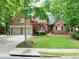 Inviting brick home showcases a two-car garage, manicured lawn, and a charming front entrance with mature trees at 5844 Brookstone Nw Walk, Acworth, GA 30101