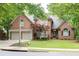 Classic brick home with a neatly landscaped front yard, mature trees, and a two-car garage at 5844 Brookstone Nw Walk, Acworth, GA 30101