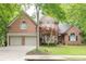 Charming brick home with a well-manicured lawn, mature trees, and a two-car garage at 5844 Brookstone Nw Walk, Acworth, GA 30101