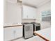 Bright laundry room featuring front load washer and dryer, cabinets, and a window at 5844 Brookstone Nw Walk, Acworth, GA 30101