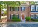 Charming two-story brick townhome featuring a red front door and manicured landscaping at 1 N Boundary Nw Pl, Atlanta, GA 30318
