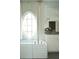 Bright bathroom featuring a soaking tub under an oval window and modern fixtures at 2067 Telfair Circle # A&B, Atlanta, GA 30324