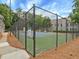 Fenced tennis court in a beautiful community setting with green trees surrounding it at 212 Abingdon Way, Atlanta, GA 30328