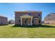 Back view of brick two-story home with a spacious backyard and manicured lawn, perfect for outdoor enjoyment at 136 Dalston Cv, Stockbridge, GA 30281