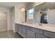 Bathroom featuring double vanity, tile floor, and a tiled shower, adjacent to a walk-in closet at 136 Dalston Cv, Stockbridge, GA 30281