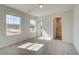 Bright bedroom with carpet, light-colored walls, two windows, and an attached bathroom at 136 Dalston Cv, Stockbridge, GA 30281