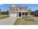 Charming two-story home with a brick facade, well-manicured lawn, and attached two-car garage at 136 Dalston Cv, Stockbridge, GA 30281