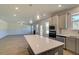 Modern kitchen island with appliances, sink, and white countertops with a view of the living room at 136 Dalston Cv, Stockbridge, GA 30281