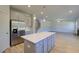 Open kitchen layout with island, stainless appliances, white countertops and view to stairs and living room at 136 Dalston Cv, Stockbridge, GA 30281