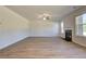 Open-concept living room with hardwood floors, a fireplace, and large windows for natural light at 136 Dalston Cv, Stockbridge, GA 30281