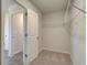 Walk-in closet with wire shelves and an open door, adjacent to bathroom with tile flooring at 136 Dalston Cv, Stockbridge, GA 30281