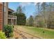 View of the back yard with a patio, mature trees, and lush grass, from the ground level at 1870 Marcia Overlook Dr, Cumming, GA 30041
