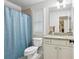 Bright bathroom with granite countertop, white cabinets, white toilet, and blue shower curtain at 1870 Marcia Overlook Dr, Cumming, GA 30041