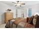 Bright bedroom with ceiling fan, wooden dresser, neutral walls and carpet, and entry to bath and closet at 1870 Marcia Overlook Dr, Cumming, GA 30041