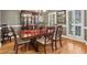 Elegant dining room featuring a hardwood floor, china cabinet, chandelier, and large windows at 1870 Marcia Overlook Dr, Cumming, GA 30041