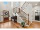 Elegant foyer with hardwood floors, staircase with iron railing, and plenty of natural light at 1870 Marcia Overlook Dr, Cumming, GA 30041