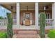 Welcoming front porch with brick accents, columns, ceiling fans, and a decorative front door at 1870 Marcia Overlook Dr, Cumming, GA 30041