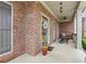 Inviting front porch with brick detail, ceiling fans, and comfortable seating area at 1870 Marcia Overlook Dr, Cumming, GA 30041