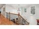 Bright hallway showcasing hardwood floors, wood and wrought iron banister, and natural light from the windows at 1870 Marcia Overlook Dr, Cumming, GA 30041