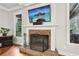 Cozy living room with brick fireplace, mantel, and flatscreen TV above at 1870 Marcia Overlook Dr, Cumming, GA 30041